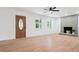 Bright living room featuring hardwood floors, a brick fireplace, and a decorative front door at 10728 Forest Dr, Matthews, NC 28105