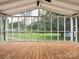 Spacious screened porch with wood floor and white trim offering scenic backyard views at 10728 Forest Dr, Matthews, NC 28105