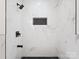 Contemporary walk-in shower with black hardware, marble-style walls, and a black honeycomb floor at 10728 Forest Dr, Matthews, NC 28105