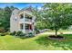 Charming two-story home with a double stacked front porch, green lawn, and mature shade tree at 112 E Heart Pine Ln, Statesville, NC 28677