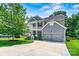 Charming two-story home featuring a two car garage, double stacked front porch, and mature shade tree at 112 E Heart Pine Ln, Statesville, NC 28677