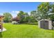 The spacious backyard with a storage shed is surrounded by a black metal fence and green grass at 11834 Planters Estates Dr, Charlotte, NC 28278