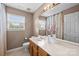 Well-lit bathroom featuring a vanity with a white countertop, wooden cabinets, and a large mirror at 11834 Planters Estates Dr, Charlotte, NC 28278
