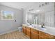 Bathroom with dual sinks, wooden cabinets, a large mirror, and a separate shower area at 11834 Planters Estates Dr, Charlotte, NC 28278
