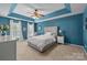 Stylish bedroom with a tray ceiling, a comfortable bed, neutral carpet, and bright, natural light at 11834 Planters Estates Dr, Charlotte, NC 28278