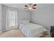 Neutral bedroom with a simple bed, cozy carpet, and a large window dressed with white curtains at 11834 Planters Estates Dr, Charlotte, NC 28278