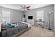 Bright bedroom with gray walls, neutral carpet, and a ceiling fan provides a calming atmosphere at 11834 Planters Estates Dr, Charlotte, NC 28278