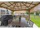 Outdoor gazebo featuring a dining table, chairs, and a grill, perfect for outdoor gatherings at 11834 Planters Estates Dr, Charlotte, NC 28278