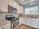 Well-lit kitchen featuring white cabinets, subway tile backsplash, and stainless steel appliances at 120 Prairie View Ct, Belmont, NC 28012