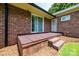 Exterior view of a brick home showing back porch with brick flooring and sliding glass door leading into the home at 1211 25Th Se St, Hickory, NC 28602