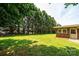 Large, grassy backyard adjacent to a brick home and bordered by tall trees at 1211 25Th Se St, Hickory, NC 28602