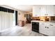 Bright kitchen with white cabinets, granite countertops, stainless steel appliances, and light gray floors leading to the living area at 1211 25Th Se St, Hickory, NC 28602