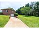 Side view of brick home featuring a long driveway leading to a basement garage at 1211 25Th Se St, Hickory, NC 28602