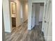 Hallway view with a bathroom entrance, wood-look flooring, and a door for closet space at 138 Zircon Dr, Statesville, NC 28625