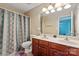 Well-lit bathroom featuring a double sink vanity and a shower with a patterned curtain at 1498 Burrell Nw Ave, Concord, NC 28027