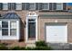 Close-up of a brick facade home showcasing the front door, a bay window, and a one-car garage at 1498 Burrell Nw Ave, Concord, NC 28027