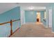 Upper level loft area with railing, door to enter bathroom, and natural lighting at 1498 Burrell Nw Ave, Concord, NC 28027