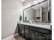 A spacious bathroom has a double sink vanity with granite countertop and a large mirror at 16547 Bastille Dr, Charlotte, NC 28278