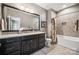 A bathroom boasts a granite countertop, tile flooring, and a bathtub with shower at 16547 Bastille Dr, Charlotte, NC 28278