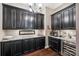 Well-appointed butler's pantry with ample storage, granite counters, and a beverage fridge at 16547 Bastille Dr, Charlotte, NC 28278