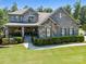 Inviting two-story home featuring a stone and brick facade, covered porch, and well-maintained landscaping at 16547 Bastille Dr, Charlotte, NC 28278