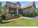 Charming home with a stone facade, inviting covered porch, and lush landscaping for a cozy curb appeal at 16547 Bastille Dr, Charlotte, NC 28278