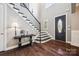 Elegant foyer featuring dark wood floors, a staircase with iron railings, and a stylish console table at 16547 Bastille Dr, Charlotte, NC 28278