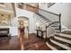 Spacious foyer showcasing hardwood floors, a staircase with black railings, and views into adjacent rooms at 16547 Bastille Dr, Charlotte, NC 28278