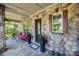 Relaxing front porch with stone facade, comfortable seating, and decorative planters adding charm and appeal at 16547 Bastille Dr, Charlotte, NC 28278