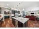 Gourmet kitchen features stainless steel appliances, granite counters, and center island overlooking living area at 16547 Bastille Dr, Charlotte, NC 28278