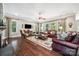Bright and open living room with hardwood floors, multiple windows, and comfortable leather seating at 16547 Bastille Dr, Charlotte, NC 28278