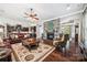 Spacious living room featuring hardwood floors, a stone fireplace, comfortable seating, and seamless flow to the kitchen at 16547 Bastille Dr, Charlotte, NC 28278