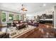 Spacious living room featuring hardwood floors, leather couches and large windows providing ample natural light at 16547 Bastille Dr, Charlotte, NC 28278