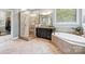 Elegant main bathroom featuring a walk-in shower, soaking tub, and vanity with granite countertops at 16547 Bastille Dr, Charlotte, NC 28278
