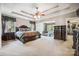 This luxurious main bedroom features tray ceilings, a ceiling fan, and a spacious layout with ensuite sitting area at 16547 Bastille Dr, Charlotte, NC 28278