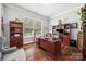 Home office featuring hardwood floors, custom built-ins, and a spacious desk at 16547 Bastille Dr, Charlotte, NC 28278