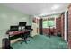 Bright basement with green carpet, black door, exercise bike, and a desk with multiple monitors at 169 Primrose Ln, Statesville, NC 28625