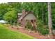 Brick home featuring a brick chimney, wooden stairs, and landscaped yard at 169 Primrose Ln, Statesville, NC 28625