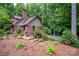 Two story brick home with a brick chimney, wooden stairs, and landscaped yard at 169 Primrose Ln, Statesville, NC 28625
