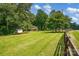 Green front yard features mature trees, shed, and a charming brick home in the background at 169 Primrose Ln, Statesville, NC 28625