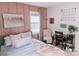 Bedroom with a pink accent wall, soft textures, and a desk area near the window at 1699 Riverdale Dr, Rock Hill, SC 29732