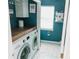Bright laundry room featuring a front load washer and dryer with hexagon tile flooring and blue accent wall at 1699 Riverdale Dr, Rock Hill, SC 29732