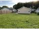 Large backyard featuring a wooden fence, green lawn, and the exterior of the home at 1714 Maribel Ave, Charlotte, NC 28216