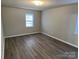 A spacious bedroom with new hardwood flooring and lots of natural light from a large window at 1714 Maribel Ave, Charlotte, NC 28216