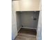 Empty storage closet featuring shelving, plumbing, and updated flooring at 1714 Maribel Ave, Charlotte, NC 28216