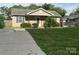Charming home with a spacious front yard, a concrete driveway, and a cozy front porch at 1714 Maribel Ave, Charlotte, NC 28216