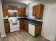 Well-lit kitchen featuring wooden cabinets, white appliances, and plenty of countertop space for cooking at 1714 Maribel Ave, Charlotte, NC 28216