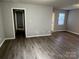 Spacious living room with hardwood floors, neutral paint, and easy access to other areas of the house at 1714 Maribel Ave, Charlotte, NC 28216