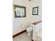 Simple powder room with light tile flooring, wood trim, and lovely botanical art at 212 Countryside Rd, Kings Mountain, NC 28086