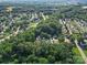 Wide aerial shot showing a residential area with tree-lined streets, and the property nestled in the greenery at 216 Devon Forest Dr, Mooresville, NC 28115